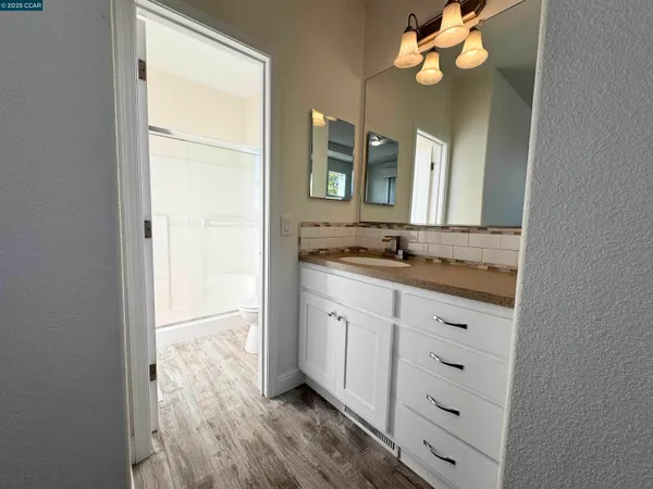 a bathroom with a granite countertop sink and a mirror