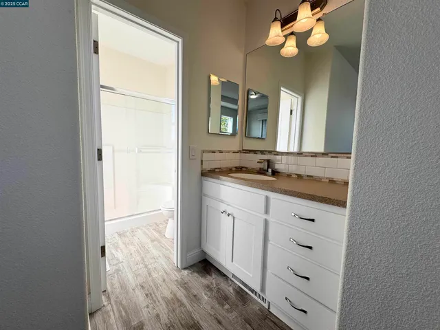 a bathroom with a granite countertop sink and a mirror