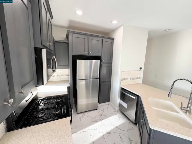a kitchen with granite countertop a refrigerator and a sink