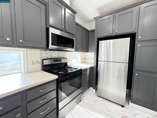 a kitchen with granite countertop wooden cabinets and stainless steel appliances