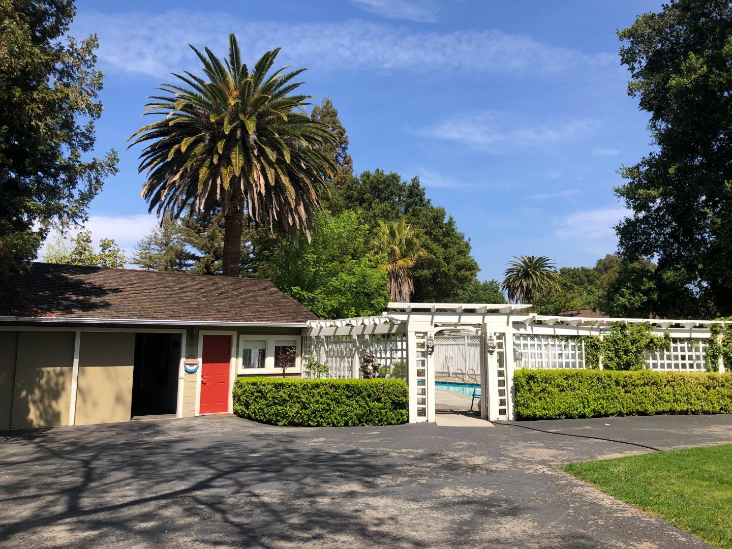 11995 Walbrook Drive Saratoga, CA 95070 - Photo 23 of 26 a front view of a house with a garden and a tree