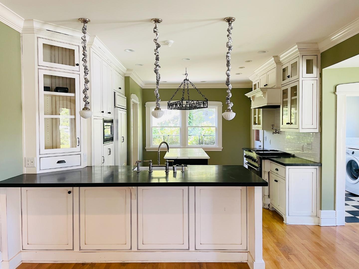 11995 Walbrook Drive Saratoga, CA 95070 - Photo 10 of 26 a kitchen with kitchen island granite countertop a refrigerator and a sink