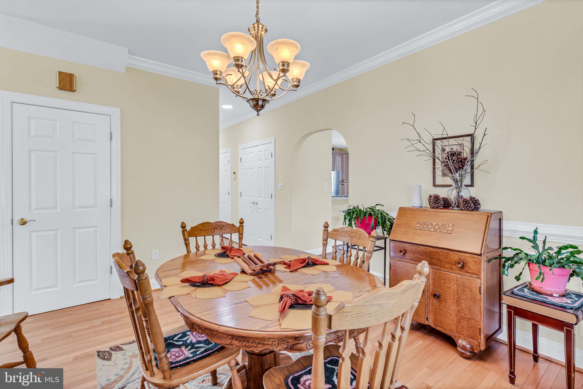 88 Old Field Road Irvington, VA 22480 - Photo 19 of 55 a view of a dining room with furniture a chandelier and wooden floor