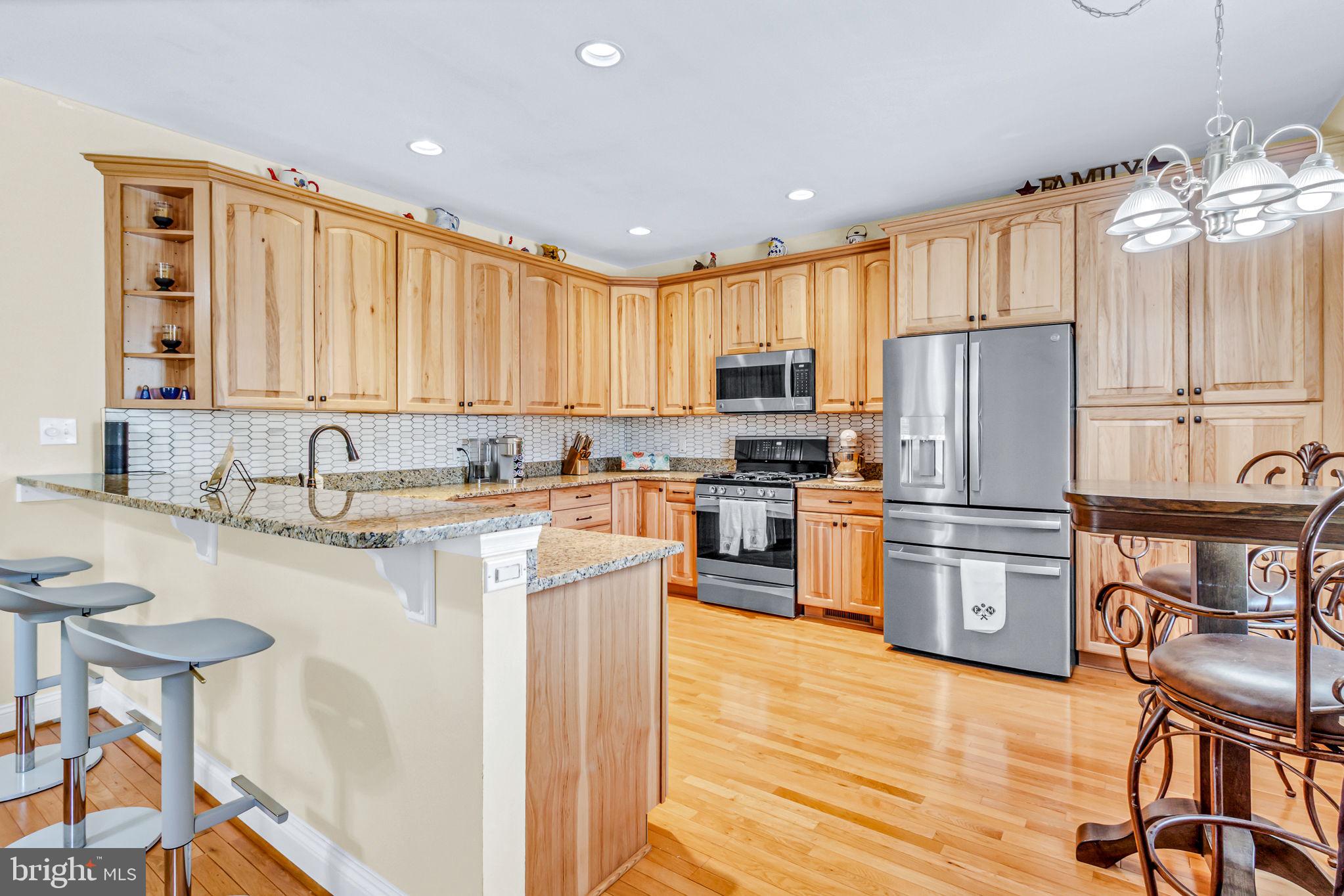 88 Old Field Road Irvington, VA 22480 - Photo 23 of 55 a kitchen with granite countertop wooden floors a refrigerator a stove a sink and cabinets