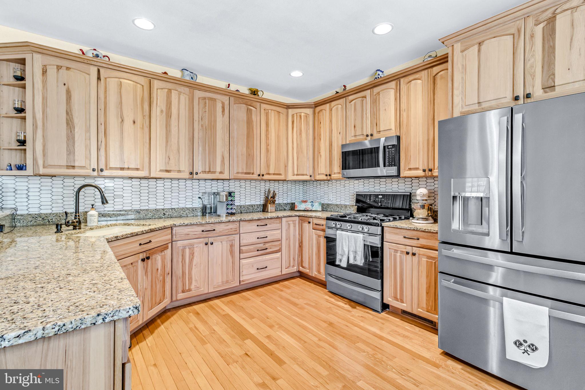 88 Old Field Road Irvington, VA 22480 - Photo 7 of 55 a kitchen with stainless steel appliances granite countertop a stove top oven a sink dishwasher and a refrigerator with wooden cabinets