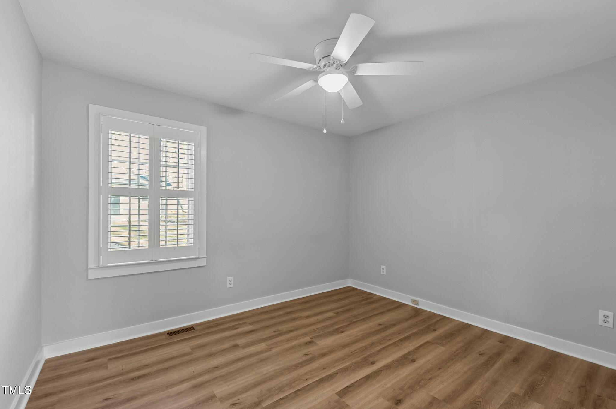 1014 Holden Road Youngsville, NC 27596 - Photo 27 of 54 an empty room with wooden floor fan and windows