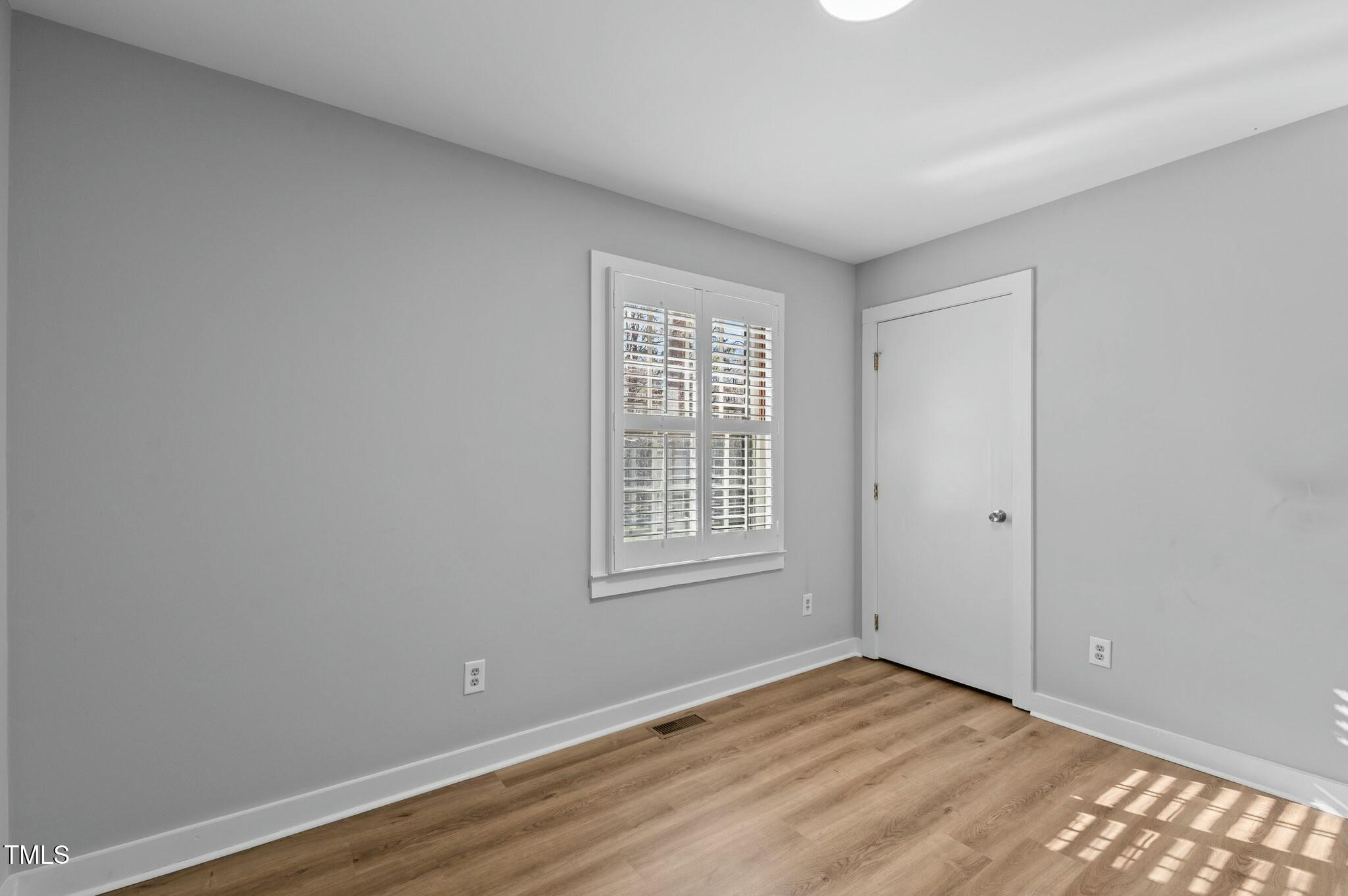 1014 Holden Road Youngsville, NC 27596 - Photo 28 of 54 a view of an empty room with wooden floor and a window