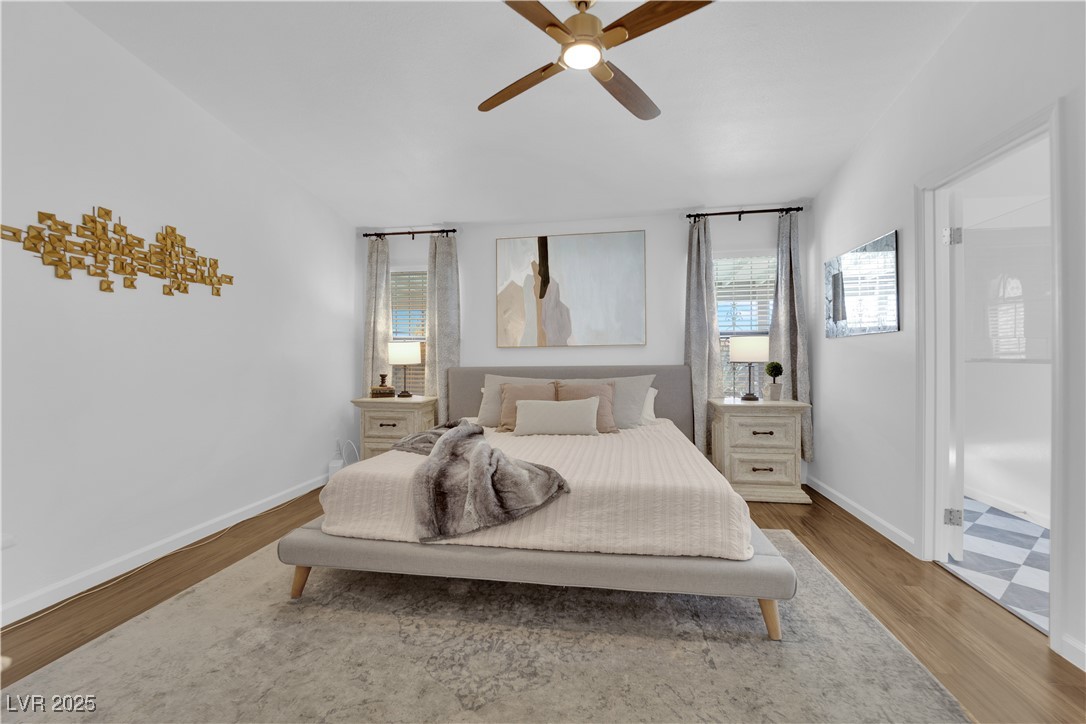 148 Triberg Court Henderson, NV 89074 - Photo 13 of 27 Primary bedroom featuring ceiling fan, vaulted ceilings, walk in closet, and LVP wood floors.