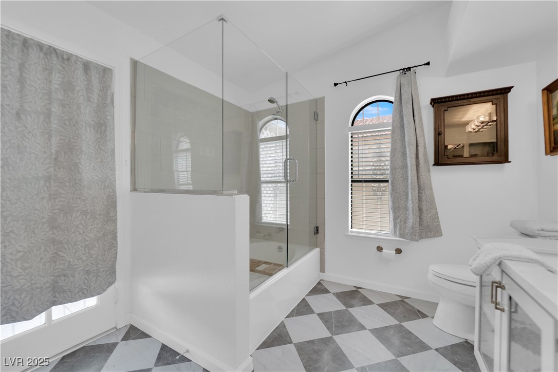 148 Triberg Court Henderson, NV 89074 - Photo 16 of 27 Primary bathroom featuring quartz vanity, toilet, and shower / bath combination with glass french door to backyard.