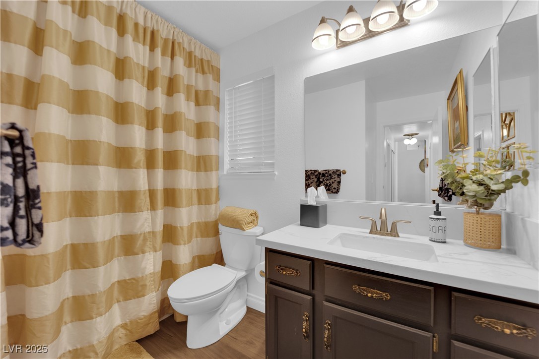 148 Triberg Court Henderson, NV 89074 - Photo 18 of 27 Full bathroom with CALCUTTA quartz vanity, toilet, wood finished floors, and a shower