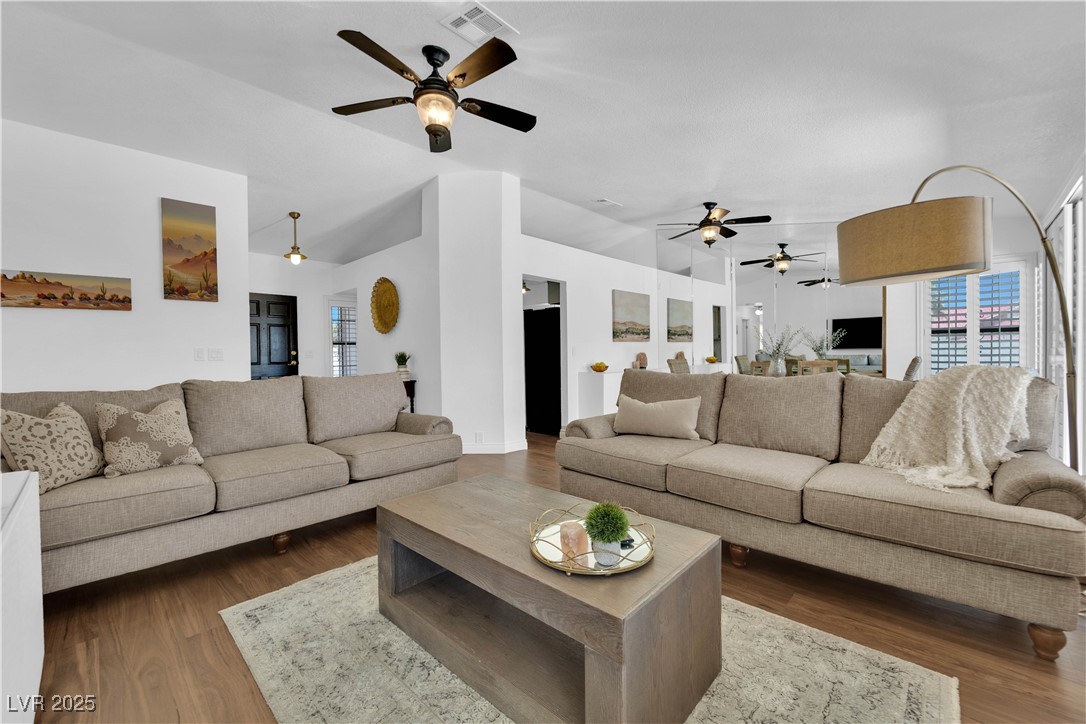 148 Triberg Court Henderson, NV 89074 - Photo 2 of 27 Living room featuring dark wood-style flooring, ceiling fan, and a wealth of natural light