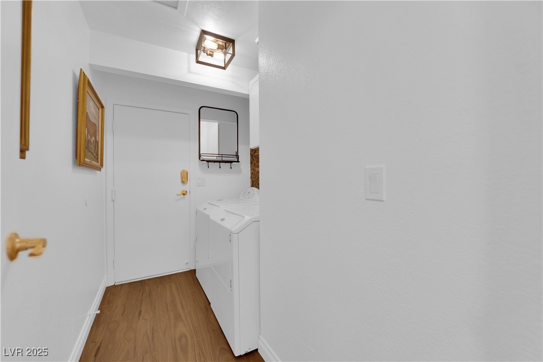148 Triberg Court Henderson, NV 89074 - Photo 22 of 27 Clothes washing area with baseboards, wood finished floors, and washing machine and clothes dryer