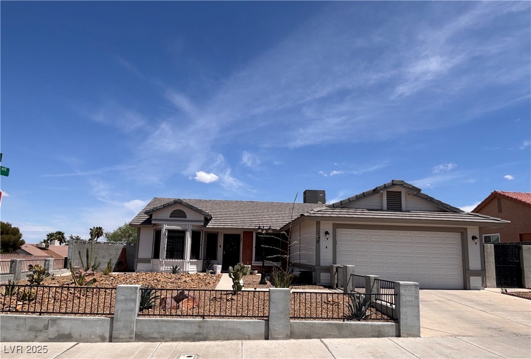 148 Triberg Court Henderson, NV 89074 - Photo 26 of 27 Ranch-style home with a fenced front yard, an attached garage, a chimney, a tiled roof, and driveway