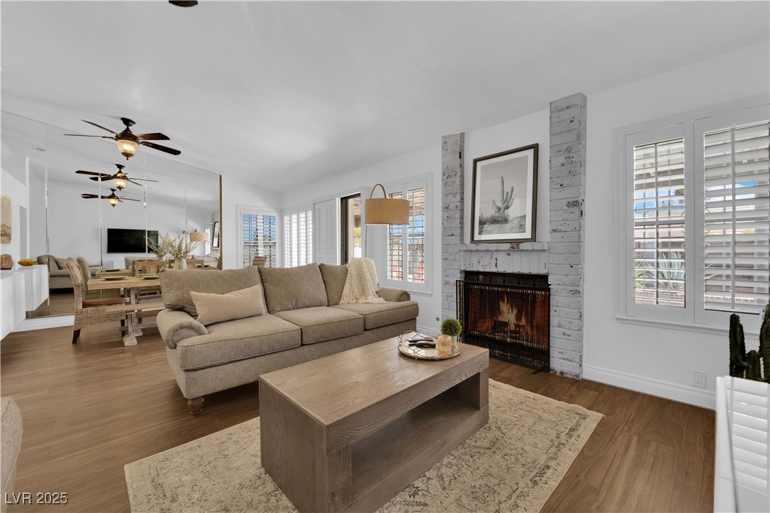 148 Triberg Court Henderson, NV 89074 - Photo 4 of 27 Great room featuring a gas fireplace, a ceiling fan, dark wood finished floors, and a wealth of natural light