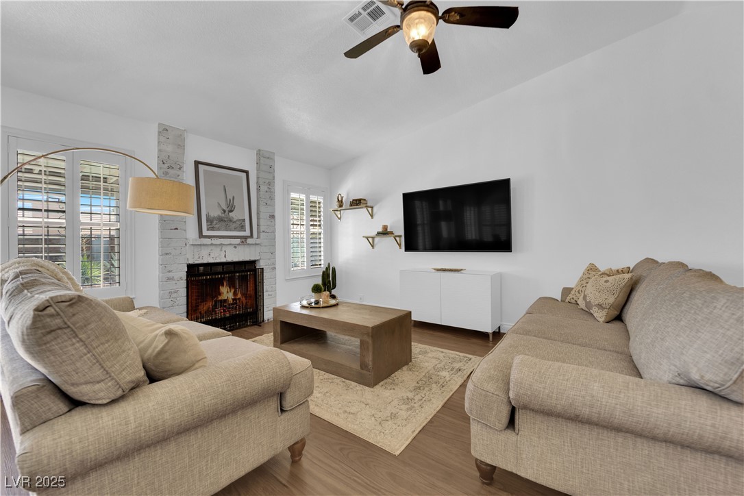 148 Triberg Court Henderson, NV 89074 - Photo 6 of 27 Living room with ceiling fan, german schmeer brick gas fireplace, wood finished floors