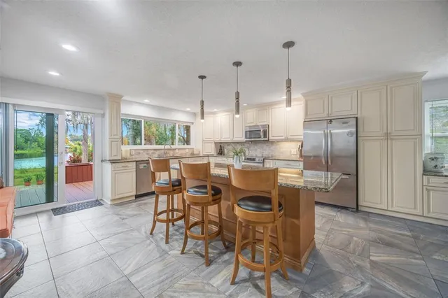 a kitchen with stainless steel appliances granite countertop a sink and a wooden floors