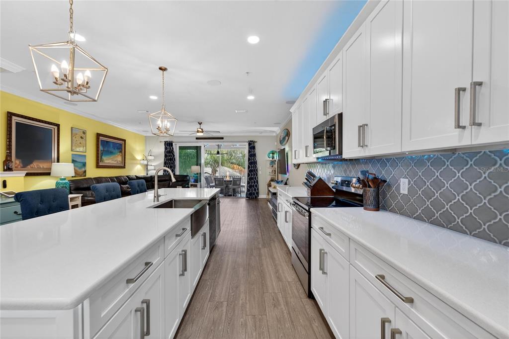 829 Callista Cay Loop Tarpon Springs, FL 34689 - Photo 17 of 91 a large kitchen with stainless steel appliances granite countertop a lot of counter space and wooden floors