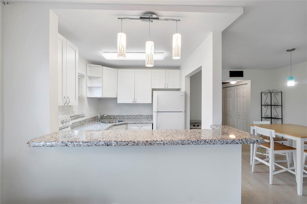 a kitchen with stainless steel appliances granite countertop a sink refrigerator and cabinets