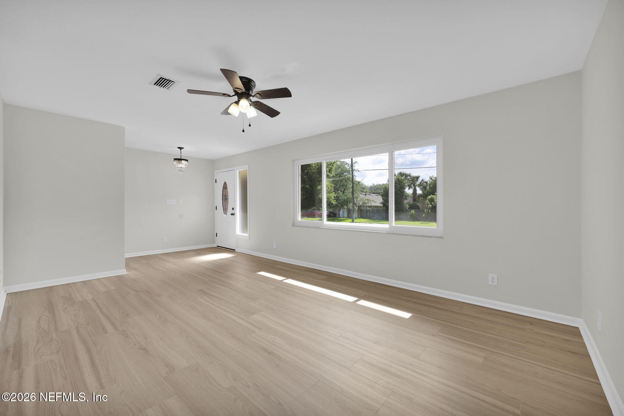 8544 Sanchez Road Jacksonville, FL 32217 - Photo 13 of 46 an empty room with wooden floor ceiling fan and windows