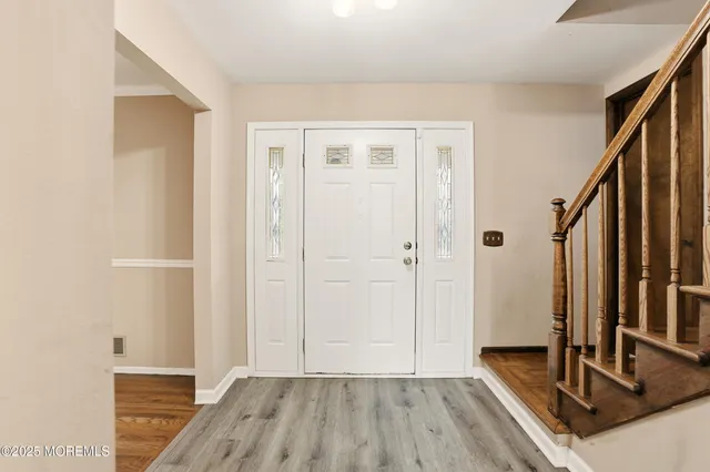 a view of a hallway with wooden floor and staircase