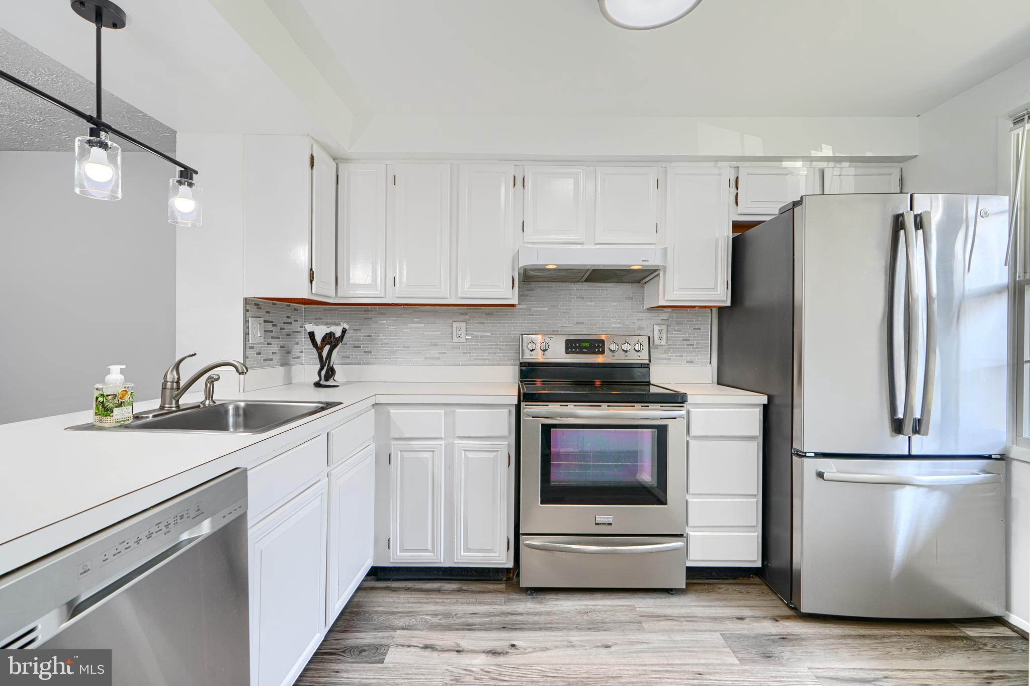 6 Stillwood Circle Nottingham, MD 21236 - Photo 3 of 26 a kitchen with a refrigerator sink and white cabinets