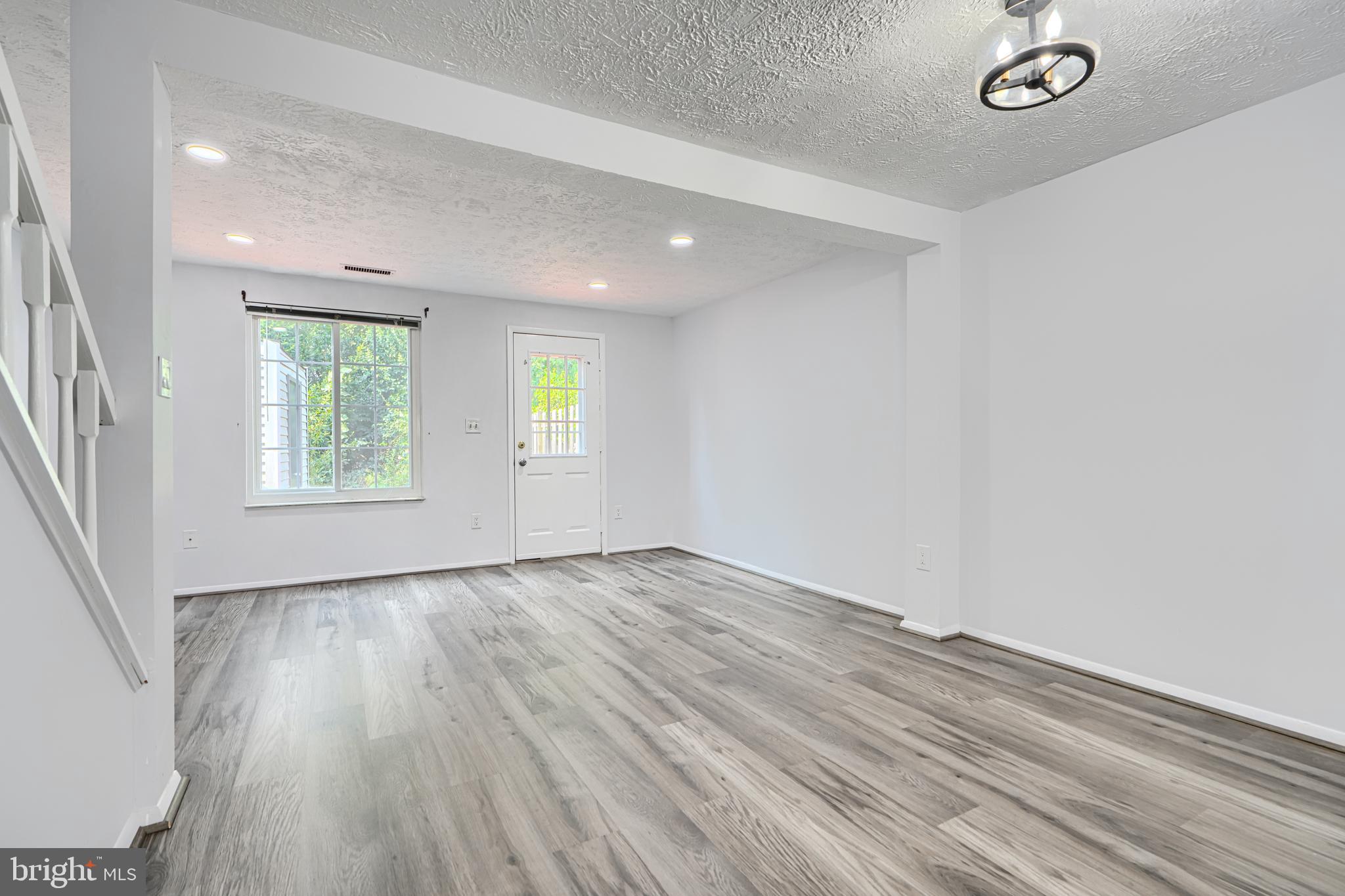6 Stillwood Circle Nottingham, MD 21236 - Photo 6 of 26 an empty room with wooden floor and windows