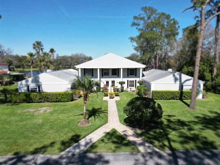 5348 Saddlebrook Way, Unit 2 Wesley Chapel, FL 33543 - Photo 1 of 38 a front view of a house with a garden