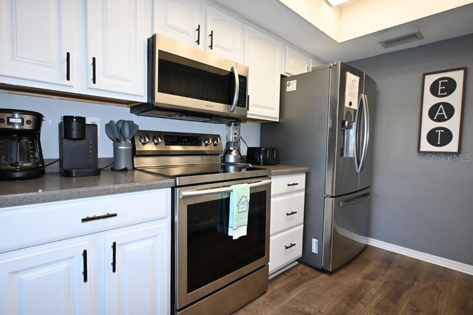 5348 Saddlebrook Way, Unit 2 Wesley Chapel, FL 33543 - Photo 11 of 38 a kitchen with stainless steel appliances granite countertop a refrigerator stove and microwave