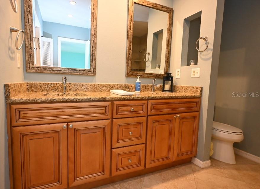 5348 Saddlebrook Way, Unit 2 Wesley Chapel, FL 33543 - Photo 23 of 38 a bathroom with a granite countertop toilet sink and mirror