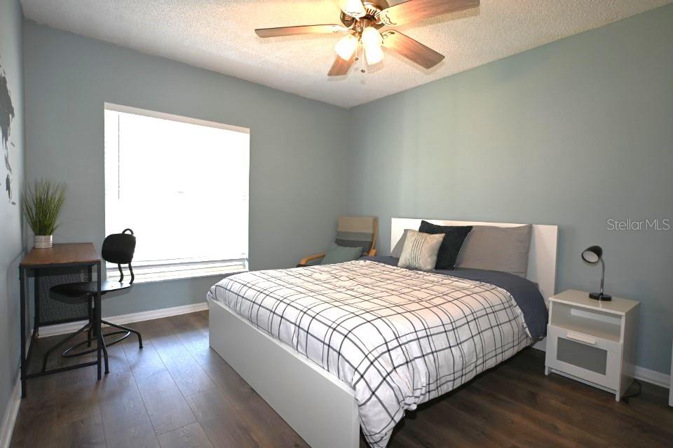 5348 Saddlebrook Way, Unit 2 Wesley Chapel, FL 33543 - Photo 30 of 38 a bedroom with a bed and wooden floor