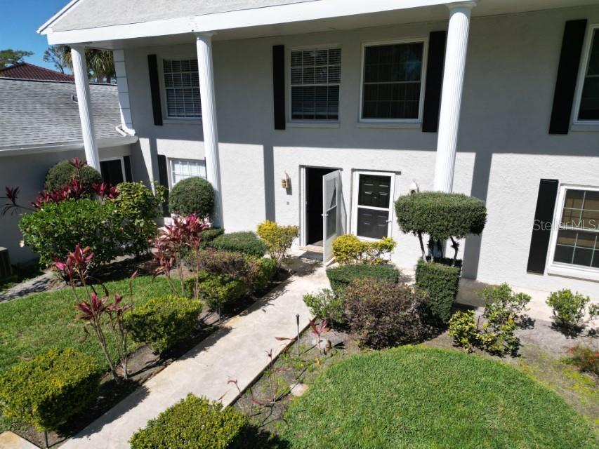 5348 Saddlebrook Way, Unit 2 Wesley Chapel, FL 33543 - Photo 3 of 38 a front view of a house with garden