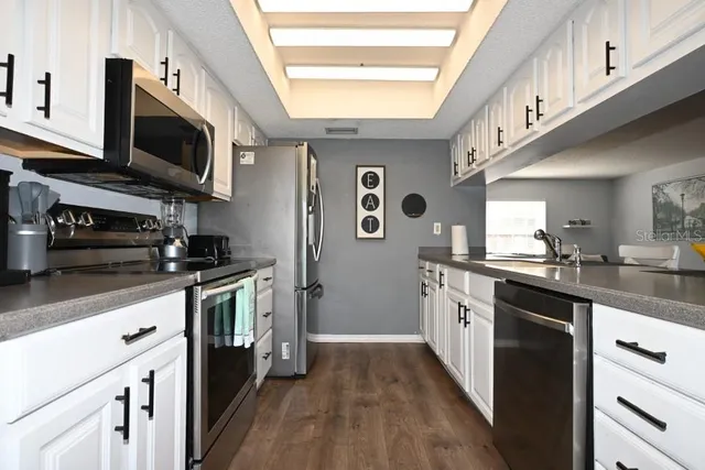 a kitchen with stainless steel appliances granite countertop a stove a sink and a microwave