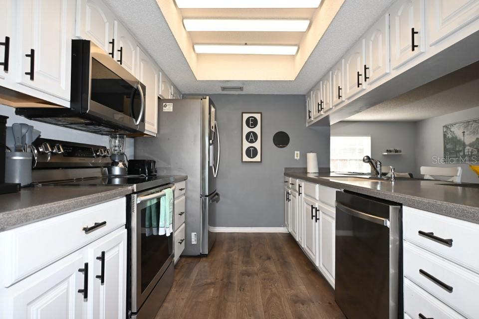 5348 Saddlebrook Way, Unit 2 Wesley Chapel, FL 33543 - Photo 9 of 38 a kitchen with stainless steel appliances granite countertop a stove a sink and a microwave