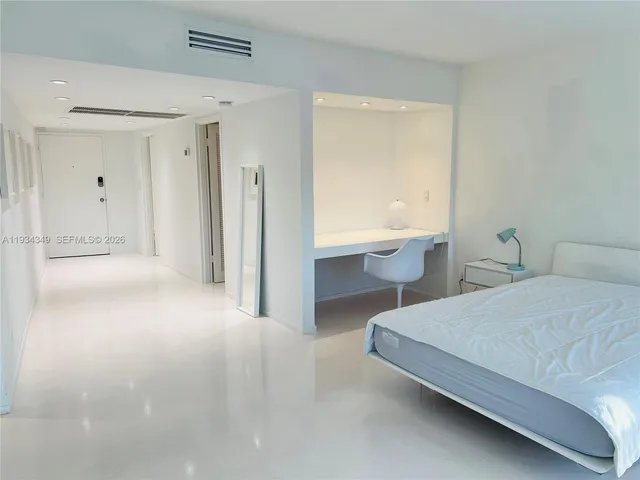 a bedroom with a bed and a large window