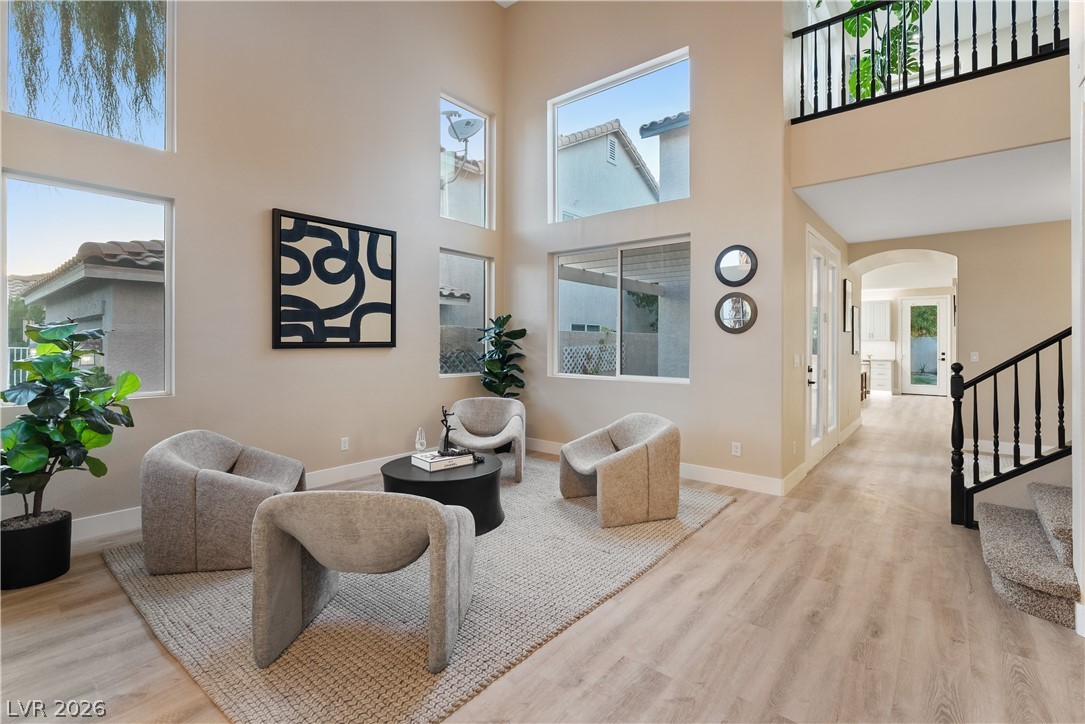 1662 Ravanusa Drive Henderson, NV 89052 - Photo 65 of 74 Natural light pours into this living space through towering windows, highlighting light wood flooring and a second-story landing.