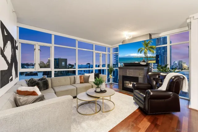 a living room with furniture fireplace and a large window