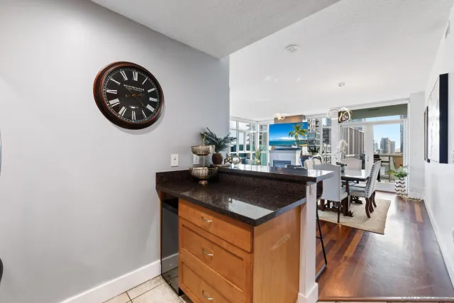 a kitchen with a sink and a stove with wooden floor
