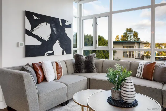 a living room with furniture flowerpot and a floor to ceiling window