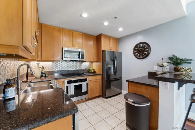 a kitchen with stainless steel appliances granite countertop a sink a stove and a refrigerator