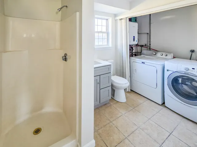 a bathroom with a sink a toilet and shower