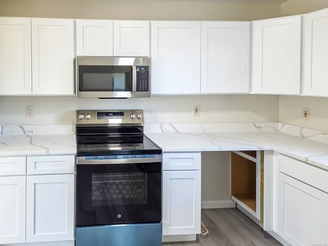 a kitchen with stainless steel appliances granite countertop a stove and a microwave