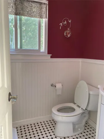 a bathroom with a toilet a window and a shower