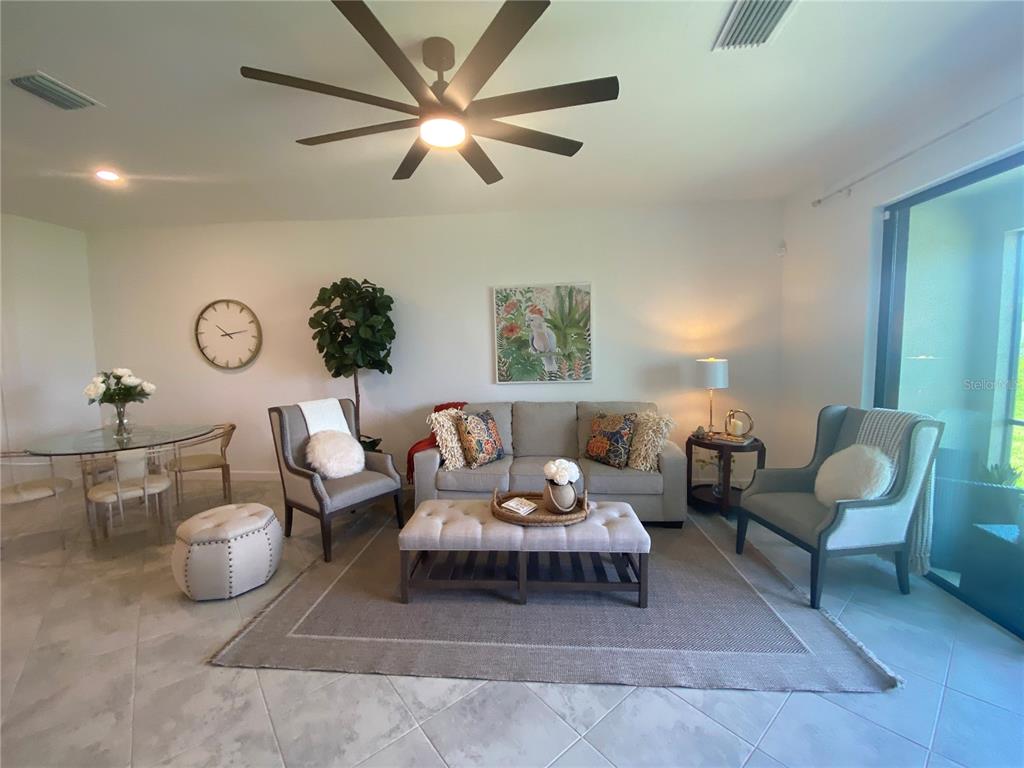 15216 Lyla Terrace Lakewood Ranch, FL 34211 - Photo 9 of 15 a living room with furniture and a chandelier fan