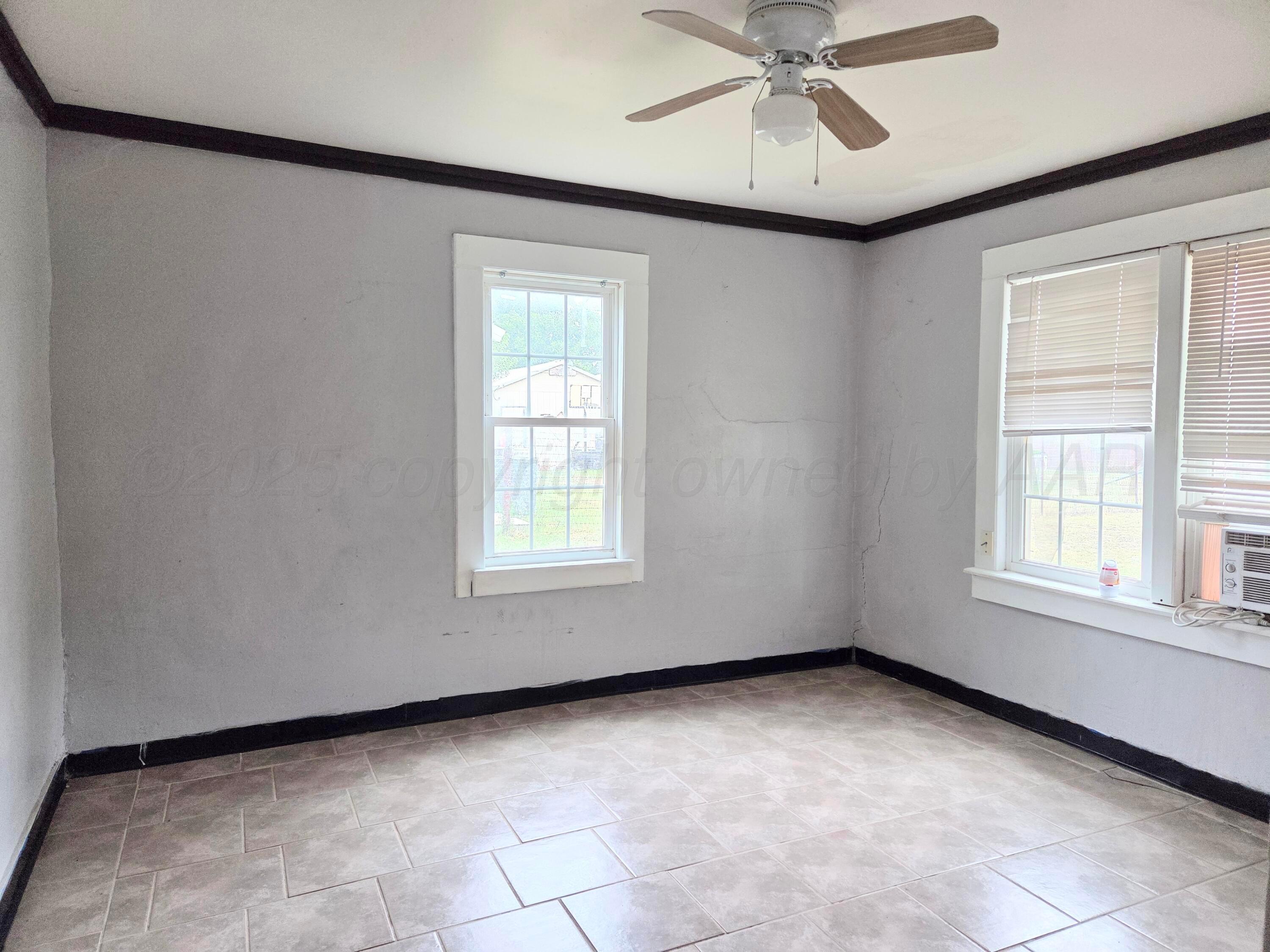 231 Main Street Quitaque, TX 79255 - Photo 13 of 23 an empty room with a ceiling fan and a window