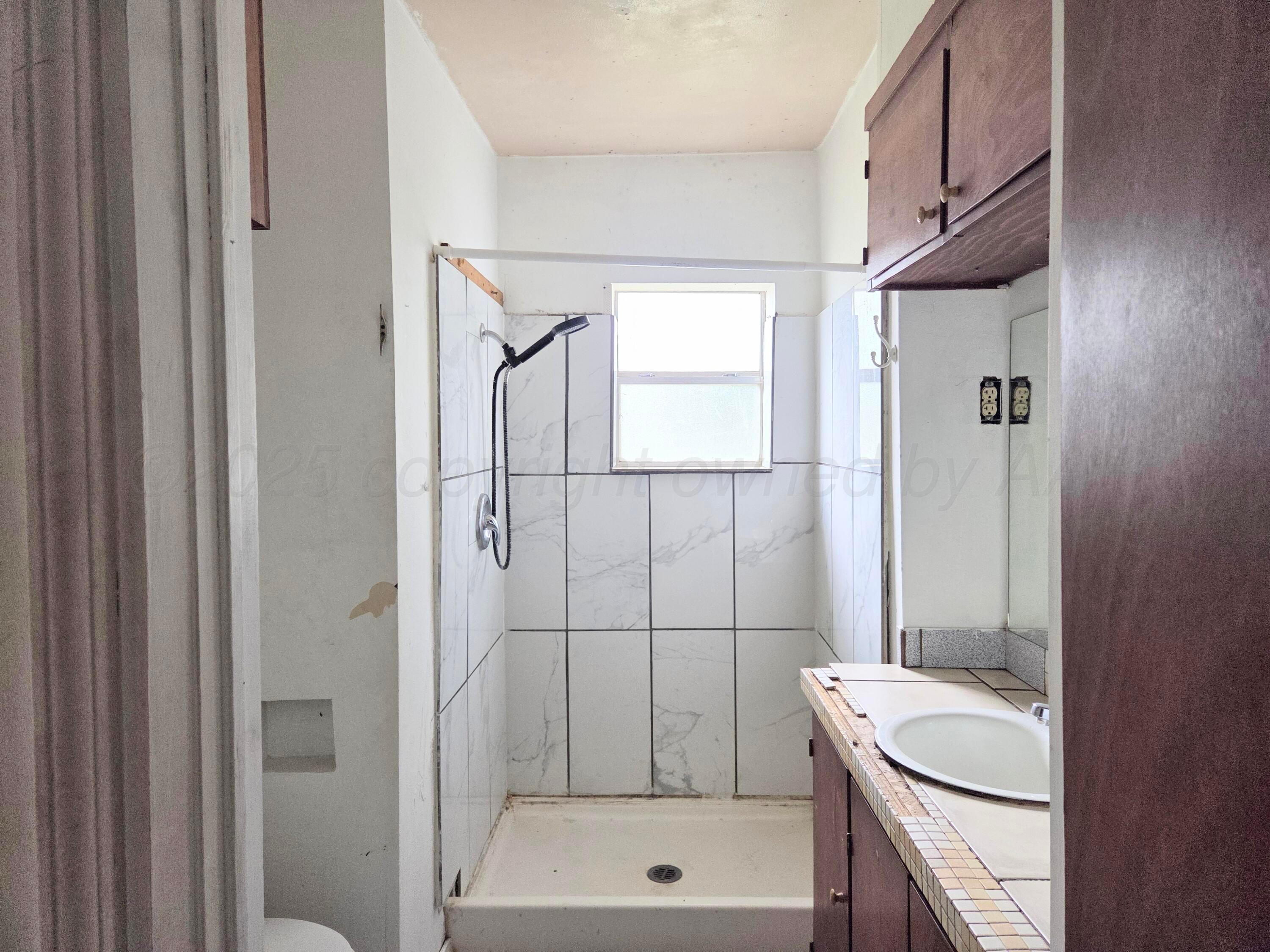 231 Main Street Quitaque, TX 79255 - Photo 15 of 23 a bathroom with a sink a toilet and shower