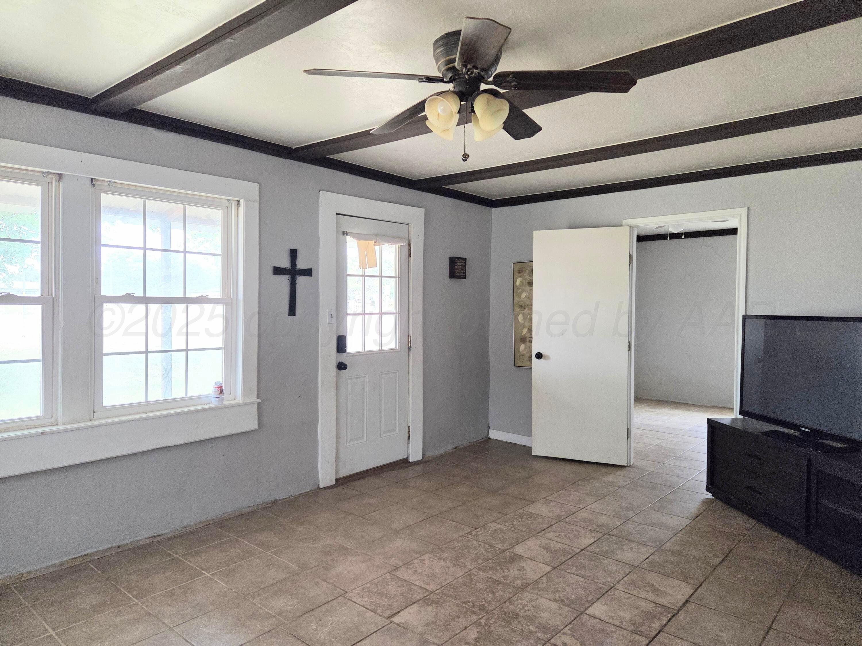 231 Main Street Quitaque, TX 79255 - Photo 3 of 23 en empty room with windows and ceiling fan