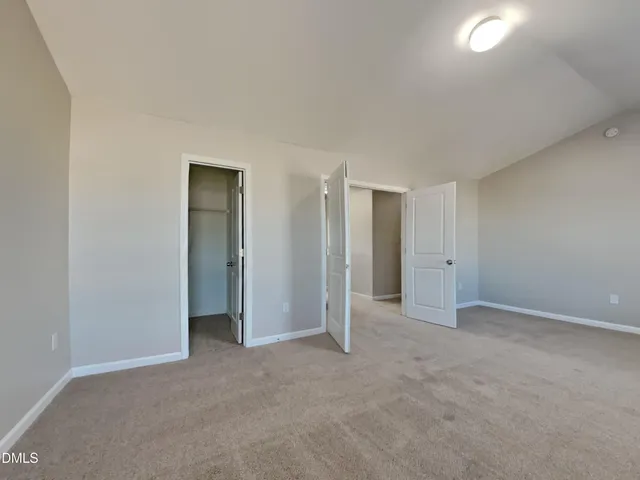 an empty room with closet and a bathroom