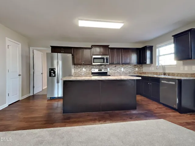 a kitchen with stainless steel appliances granite countertop a stove a sink dishwasher and a refrigerator
