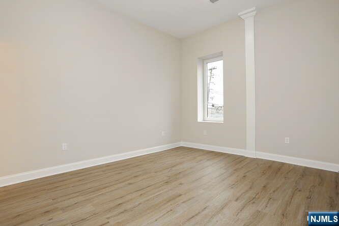 385 Passaic Avenue, Unit 6 Lodi, NJ 07644 - Photo 11 of 23 an empty room with wooden floor and windows
