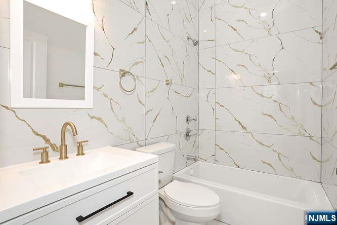 385 Passaic Avenue, Unit 6 Lodi, NJ 07644 - Photo 15 of 23 a bathroom with a sink a toilet and a bathtub